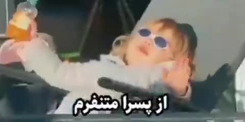 کودکی با عینک آفتابی و نوشیدنی نارنجی روی صندلی نشسته است، متن میگوید «از پسرا متنفرم».